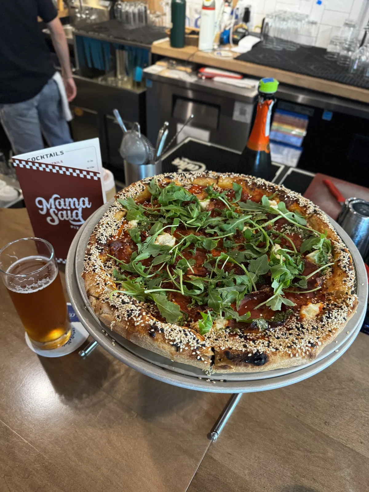 Pizza with arugula and a glass of beer